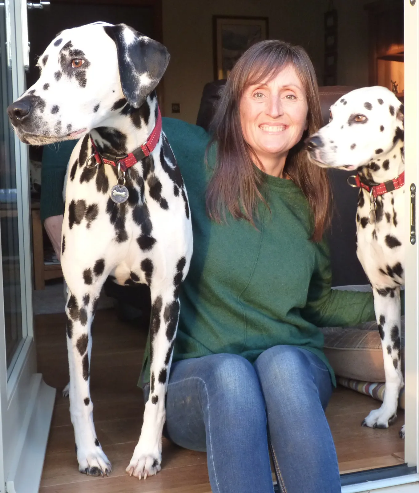 Linda Scarff sitting at home with two dalmatians